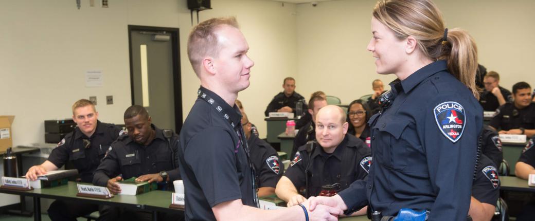 male officer shaking hands with female trainee