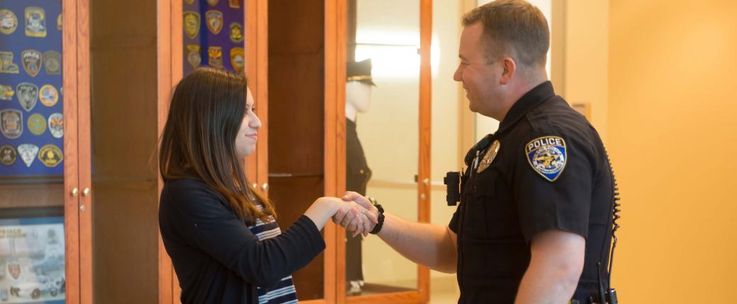 Police officer shaking hands with young woman