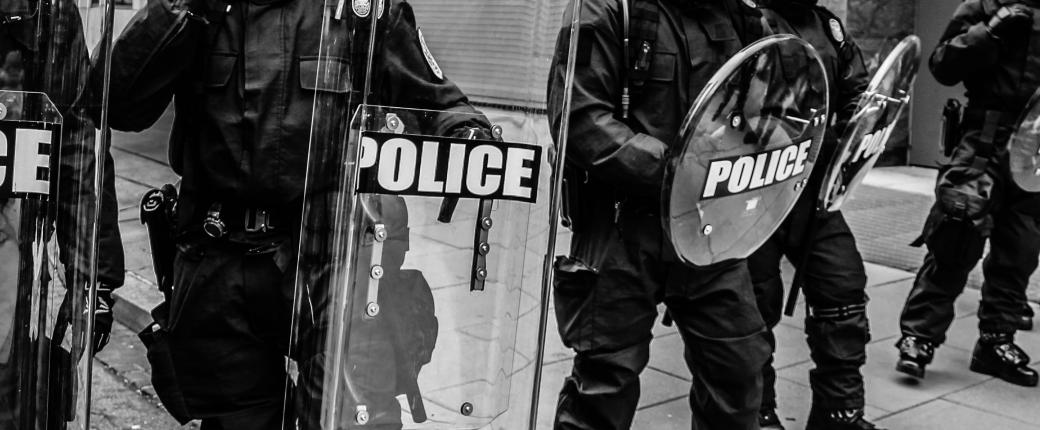 Police officers holding crowd control shields