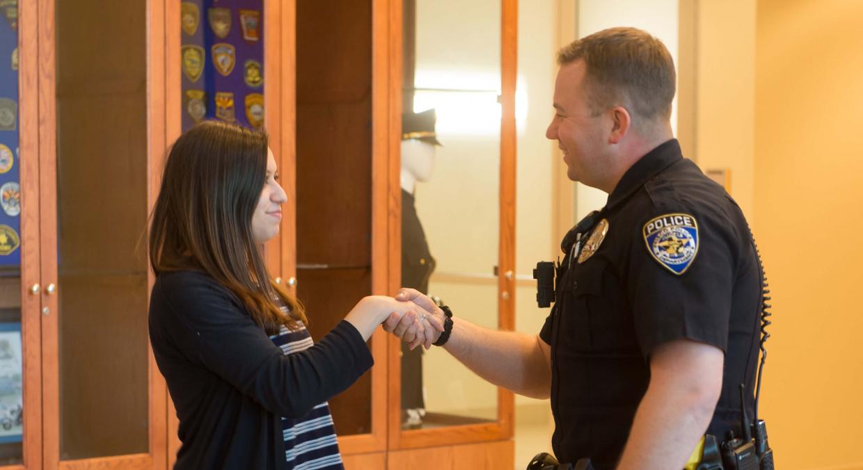 Police officer shaking hands with young woman