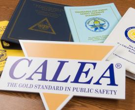 CALEA sign and CALEA documents and manuals resting on a table